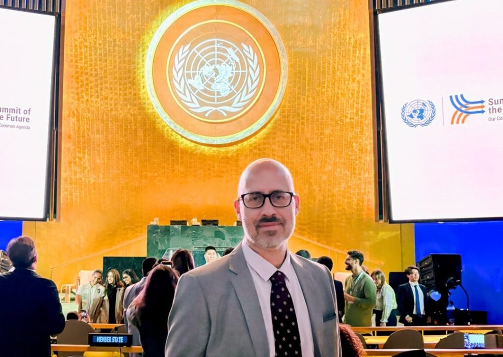 Jean Philippe standing in front of the speaker's rostrum and podium.